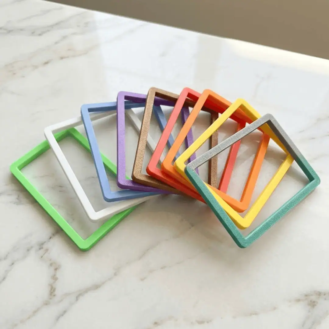 Set di cornici colorate in legno su superficie di marmo bianco.