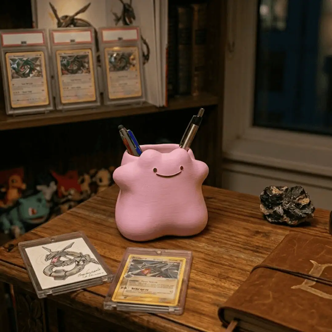 Pikachu-themed pen holder with Pokémon cards on a wooden desk.